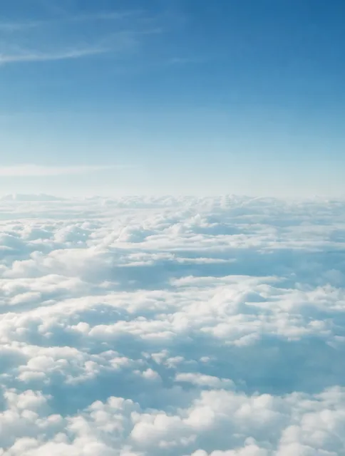 飛行機の窓から見下ろす雲海と青空